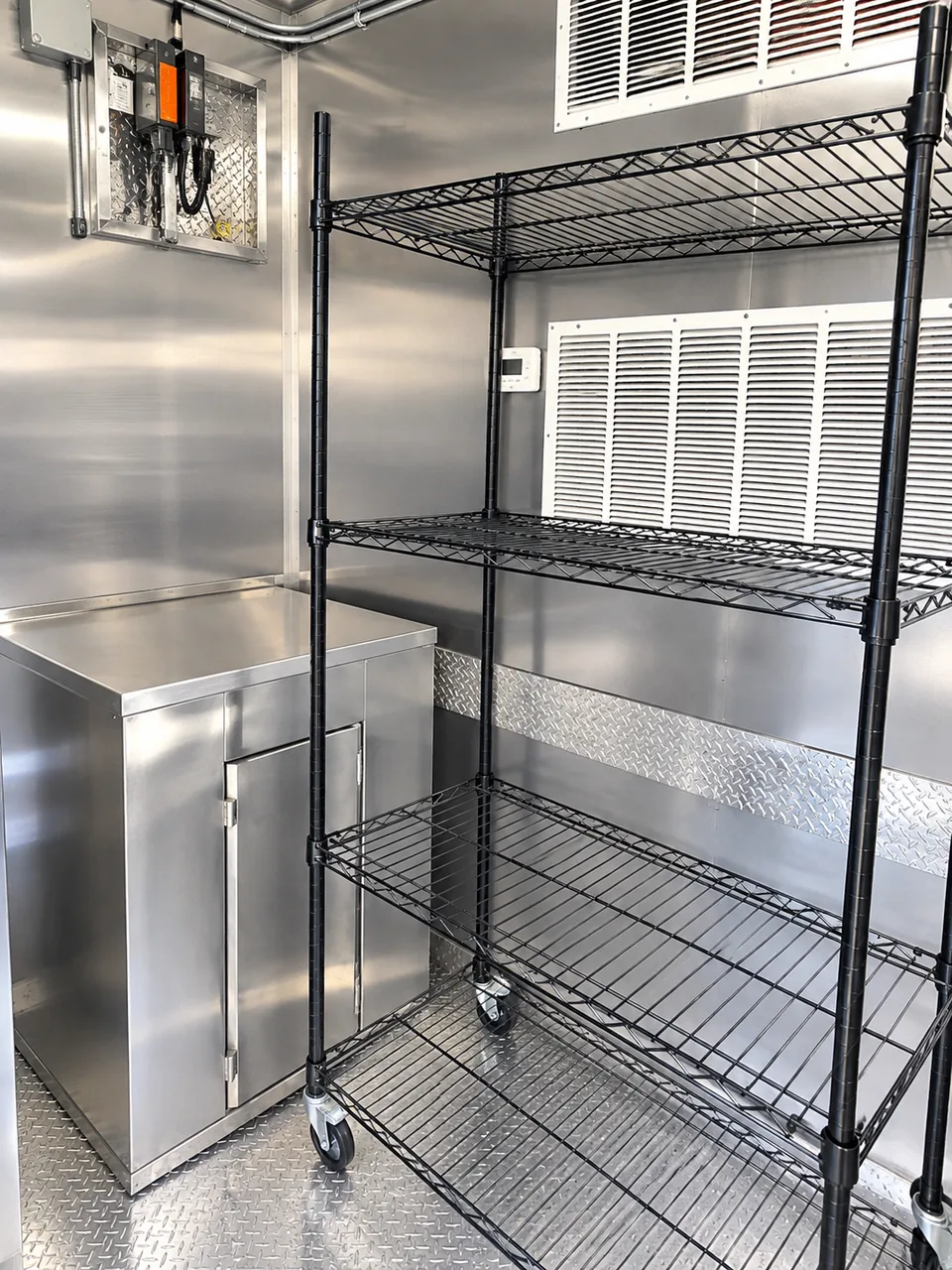 Storage racks and stainless work surfaces inside a kitchen trailer
