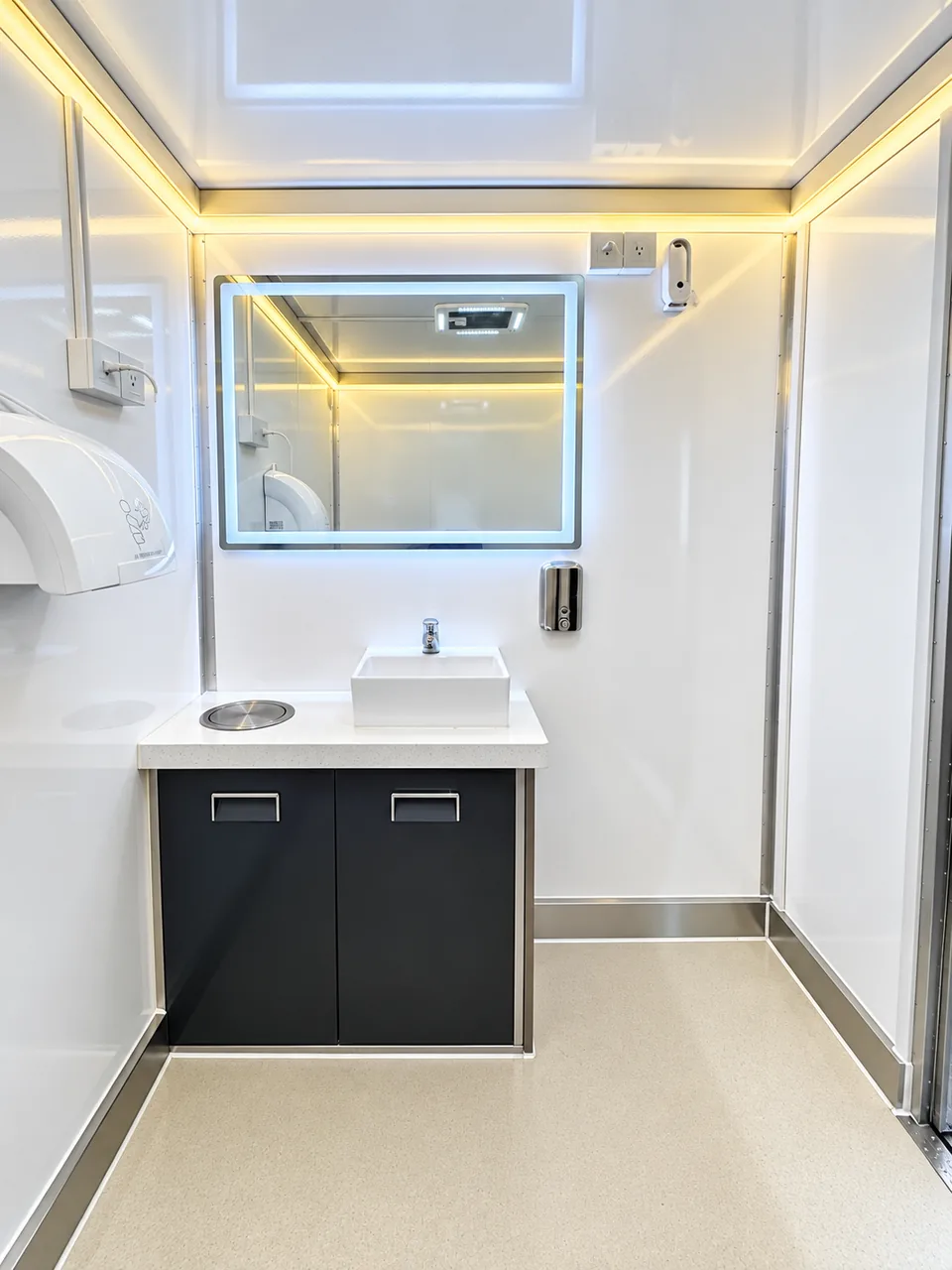 Sink and mirror inside the shower and restroom trailer